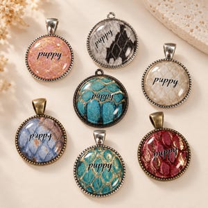 May include: Seven round metal pendants featuring a glass cabochon top with a snake skin pattern in various colours including pink, grey, beige, blue, and red, each with the word puppy printed in black script across the centre of the design.