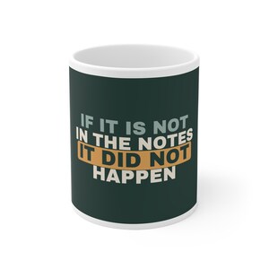 May include: A dark green ceramic mug with white and tan text that reads, IF IT IS NOT IN THE NOTES IT DID NOT HAPPEN. The mug features a white interior and rim, with the text arranged in a block layout, highlighting the phrase in a tan rectangular box.
