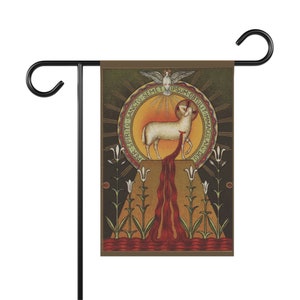 May include: A garden flag with a religious image of a lamb with a halo and a dove above it. The lamb is standing on a platform with a red stream of blood flowing from its side. The image is surrounded by a circle with Latin text. The flag is brown with gold accents.