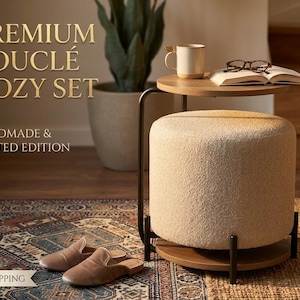 May include: A round cream-coloured bouclé ottoman with a dark metal frame and a circular wooden tabletop. The text reads PREMIUM BOUCLÉ COZY SET and HANDMADE & LIMITED EDITION. A pair of tan slippers rests nearby on a patterned rug.