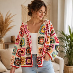 May include: A long-sleeved cardigan made of multi-colored crochet granny squares in shades of red, yellow, blue, green, and pink, joined by an off-white yarn. The garment features a V-neckline and a red crochet border along the front opening.
