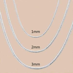 Puede incluir: Tres cadenas de serpiente de color plateado dispuestas en forma de U anidada. Las cadenas están etiquetadas con sus anchos respectivos de 1mm, 2mm y 3mm. Cada cadena presenta un diseño de eslabones lisos, flexibles y redondeados.