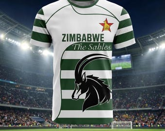 May include: A white and green striped short-sleeve t-shirt featuring the text ZIMBABWE The Sables, a black silhouette of an antelope head, and a red star emblem with a gold bird icon on the upper chest area of the garment.