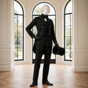 Op de afbeelding: Een zwart rokkostuum bestaande uit een double-breasted jasje met gouden knopen, een bijpassend vest en een pantalon. De set bevat een zwarte vlinderdas, zwarte leren handschoenen en een zwarte hoge hoed in de hand, gedragen door een witte etalagepop.