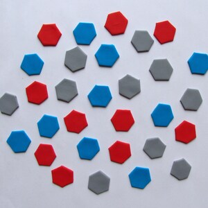 May include: A collection of 25 colorful geometric shapes, including red, blue, and gray, arranged in a circular pattern on a white background.