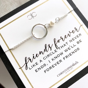 May include: A silver chain bracelet with a circle charm and a single pearl. The bracelet is displayed on a white card with the text "friends forever like a circle that never ends, I know we'll be forever friends" and the brand name "CHRISTOPHERkate JEWELRY".