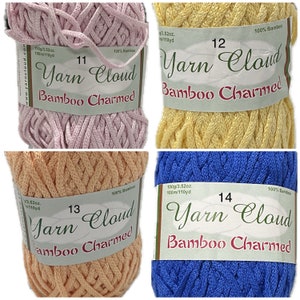 May include: Four skeins of yarn in different colors: pink, yellow, peach, and blue. Each skein has a label that reads "Yarn Cloud Bamboo Charmed" with a number from 11 to 14. The label also includes the weight and yardage of the yarn.