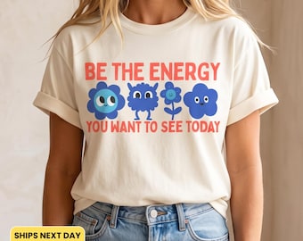 Sei die Energie, die du heute sehen willst – T-Shirt mit positivem Spruch, Retro-Blumen-Motivationsshirt, Shirt für gute Laune, Geschenk für sie, Wohlfühlfarben