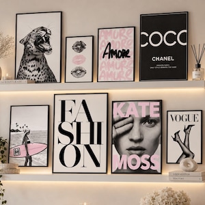 May include: A gallery wall arrangement featuring seven framed prints on two shelves. The art includes a leopard, lips, the word AMORE, a COCO CHANEL poster, a surfer with a pink board, the word FASHION, a KATE MOSS portrait, and a VOGUE cover.
