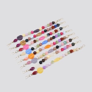 May include: A collection of seven beaded bag straps, each featuring a variety of multicoloured, multi-shaped polished stones and beads. Each strap is finished with gold-toned metal lobster claw clasps at both ends for secure attachment.