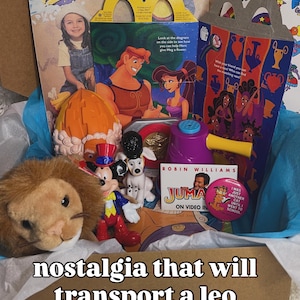 May include: A collection of vintage toys and memorabilia including a McDonald's Hercules Happy Meal box, a plush lion, a Mickey Mouse figurine, a dalmatian figure, a purple plastic toy, a Jumanji video promotional card, and a Garfield pin.