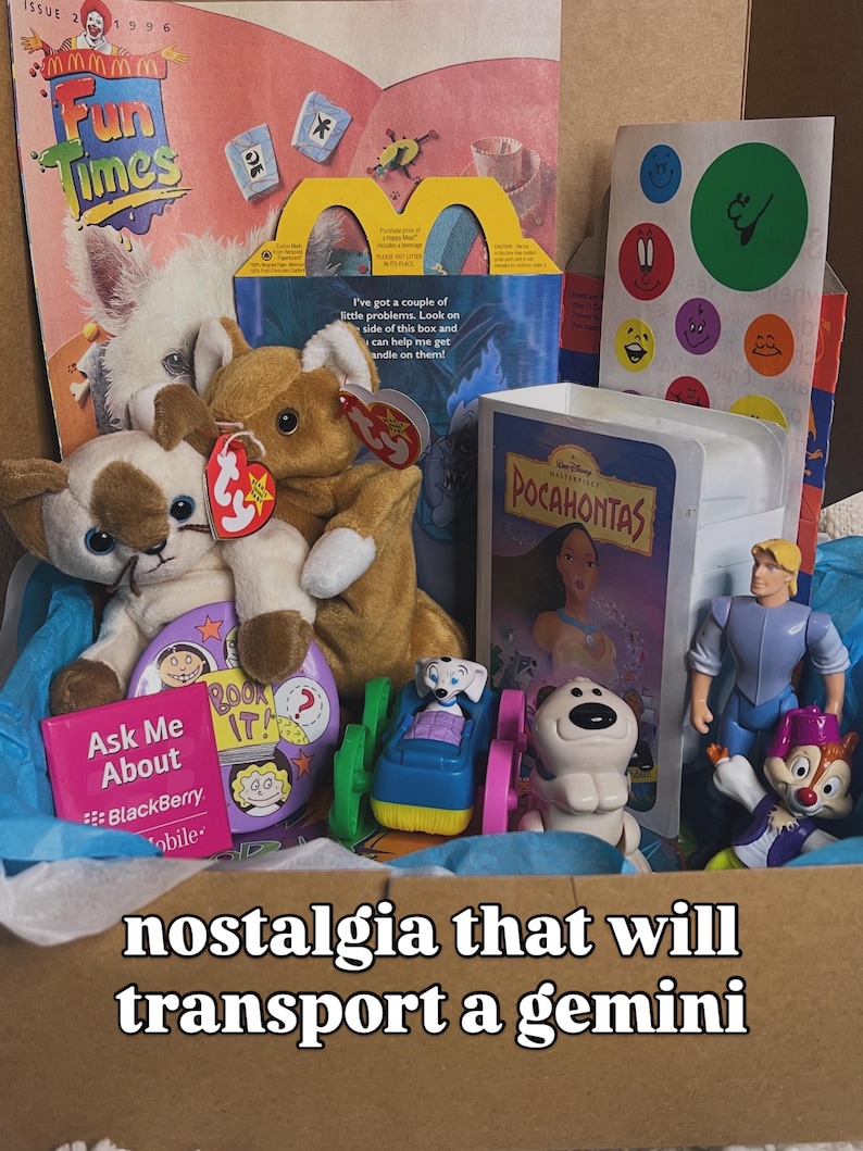 May include: A collection of 1990s memorabilia including a Fun Times magazine, a McDonald's Happy Meal box, a Pocahontas VHS tape, Ty plush toys, a Blackberry promotional card, and various plastic character figurines nestled in blue tissue paper.