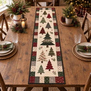 May include: A rectangular fabric table runner featuring a cream-colored center panel decorated with various quilted Christmas tree patterns in shades of green and red, surrounded by a patchwork border of red, green, and grey patterned fabric squares.