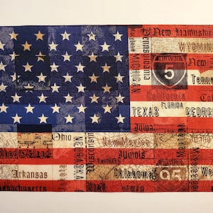 May include: Rectangular textile featuring the American flag design. The blue field displays white stars, while the stripes incorporate state names and highway signs. The color palette includes red, white, and blue.