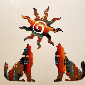 May include: Two wolf silhouettes facing each other and a sun shape positioned above them. Each figure features a vibrant, multi-colored geometric pattern with shades of orange, red, brown, teal, and black, arranged in repeating triangular motifs.