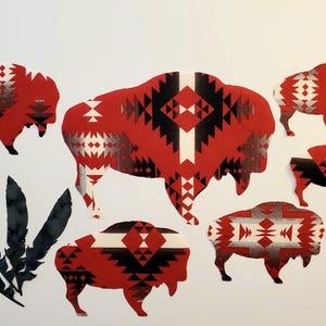 May include: A collection of die-cut stickers featuring five bison silhouettes and a cluster of four black feathers. Each bison is decorated with a red, black, and white geometric pattern. The stickers are arranged on a plain white surface.