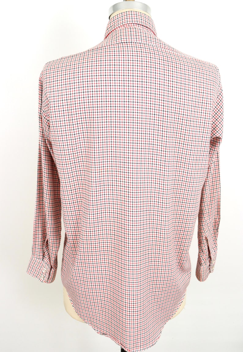 May include: A long-sleeved button-down shirt with a red and black checkered pattern.