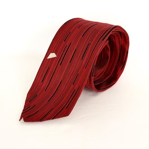 May include: A red tie with black vertical stripes and a small white geometric accent. The tie is rolled up, showcasing its texture and design. This formal accessory is suitable for business or special occasions.
