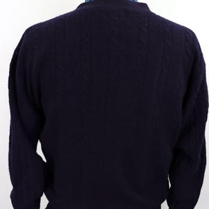 Puede incluir: Un su&eacute;ter azul marino oscuro con un patr&oacute;n de punto de cable. El su&eacute;ter tiene mangas largas y cuello redondo. La parte trasera del su&eacute;ter es visible, mostrando la textura del tejido. El su&eacute;ter se exhibe en un maniqu&iacute;.
