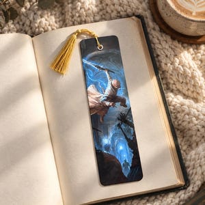 May include: A rectangular bookmark featuring a fantasy illustration of a figure wielding a glowing blue sword in a dark stone corridor, complete with a metallic eyelet and a golden yellow tassel attached to the top edge of the bookmark.