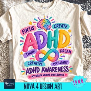 May include: A cream-coloured t-shirt featuring a colourful graphic with a brain illustration, an infinity symbol, and the text: FOCUS, CREATE, THINK, DREAM, CREATIVE, BRILLIANT, ADHD, ADHD AWARENESS, and MY BRAIN WORKS DIFFERENTLY.
