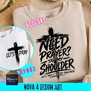 May include: A beige crewneck sweatshirt featuring a black graphic of a cross with the text "NEED PRAYER? TAP MY SHOULDER LET'S TAKE IT TO GOD TOGETHER." A circular inset shows a white sweatshirt with a cross and the text "LET'S PRAY."