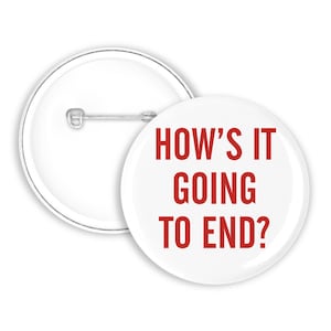 Puede incluir: Una chapa redonda con fondo blanco y el texto en rojo HOW'S IT GOING TO END? impreso en una fuente sans-serif. La parte posterior de la chapa es blanca y cuenta con un mecanismo de alfiler de metal plateado para sujetar a la ropa.