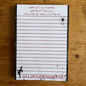 Könnte beinhalten: Ein rechteckiger Notizblock mit weißem Papier und horizontalen roten Linien. Der Text oben lautet DEFIANT TO THE END, WE HEAR THE CALL TO CARRY ON, WE'LL CARRY ON. Ein schwarzes Spinnensymbol ist rechts und eine schwarze Marschfigur ist unten links.