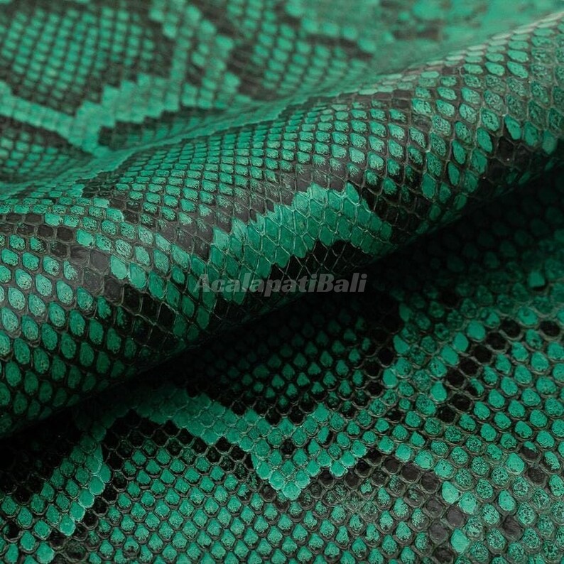 May include: A textured material featuring a repeating snakeskin pattern in vibrant emerald green and deep black. The surface displays a detailed, scaled appearance with a consistent geometric arrangement across the entire visible area.