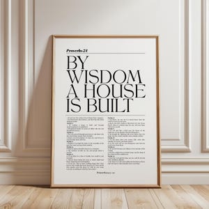 Puede incluir: Una lámina de arte mural vertical enmarcada que presenta el texto Proverbs 24 en la parte superior, seguido del gran título en negrita BY WISDOM A HOUSE IS BUILT, y el texto completo de los versículos 1 al 22 en una fuente serif más pequeña.