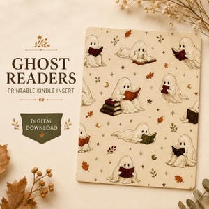May include: A rectangular Kindle insert featuring a repeating pattern of white ghosts reading books, interspersed with small brown autumn leaves, stars, and crescent moons. The text GHOST READERS PRINTABLE KINDLE INSERT DIGITAL DOWNLOAD is visible.