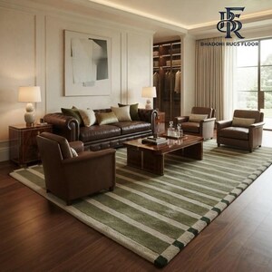 May include: A large area rug featuring a repeating pattern of wide olive green and cream-coloured stripes. The rug is positioned on a dark wood floor in a living room setting, underneath a brown leather sofa, two matching armchairs, and a coffee table.