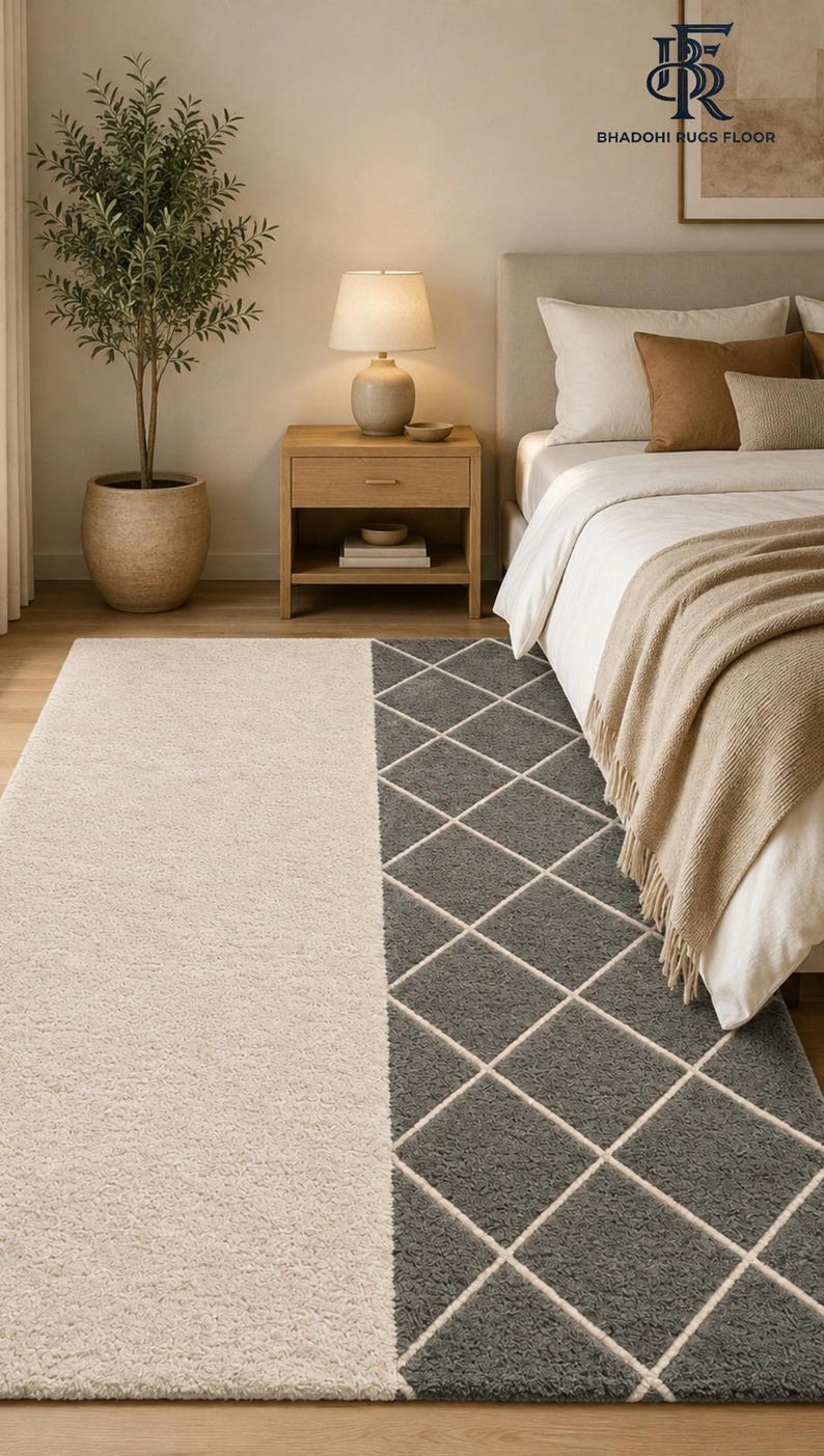 May include: A rectangular area rug featuring a split design with one half in solid cream and the other half in dark gray with a white diamond grid pattern. The rug has a textured, shaggy pile surface and is positioned on a wooden floor.