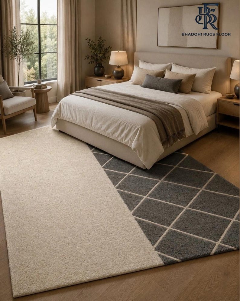 May include: A rectangular area rug featuring a split design with a solid cream-colored section on the left and a dark gray section on the right, which is decorated with a white diamond grid pattern. The rug is positioned on a wooden floor.