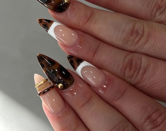 Unghia artificiale personalizzata, effetto tartaruga e french manicure bianca, dettaglio con ciondolo in metallo dorato, unghia in gel riutilizzabile realizzata a mano, manicure elegante e di lusso.