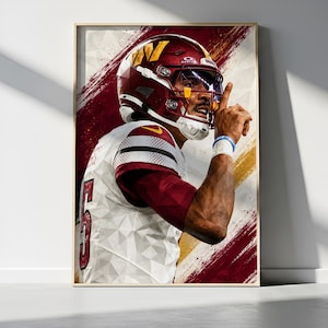 May include: A framed poster featuring a football player in a white and burgundy uniform with the number 5, wearing a burgundy helmet with a yellow W logo. The player holds a finger to their lips in a hush gesture against a geometric background.