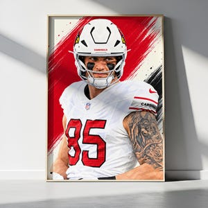 Könnte beinhalten: Ein gerahmter digitaler Kunstdruck eines Footballspielers im weißen Cardinals-Trikot mit der roten Nummer 85, einem weißen Helm und schwarzer Schminke unter den Augen vor einem Hintergrund aus dynamischen roten und schwarzen Pinselstrichen.