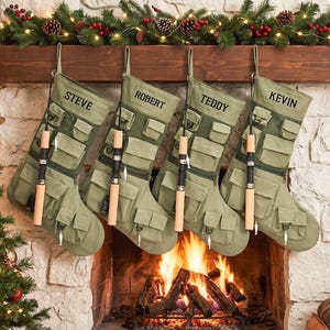 Puede incluir: Cuatro calcetines navideños de lona color verde oliva con múltiples bolsillos utilitarios, un accesorio para caña de pescar y los nombres Steve, Robert, Teddy y Kevin bordados en hilo negro en el borde superior de cada calcetín.