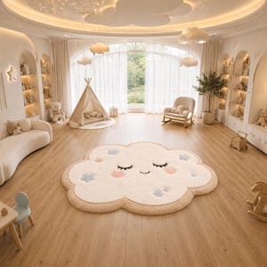 May include: A large, cloud-shaped area rug featuring a cream-colored center with a smiling face, closed eyes, and pink cheeks. The rug is accented with small blue and pink flower-like shapes and has a tan border, placed on a wooden floor.