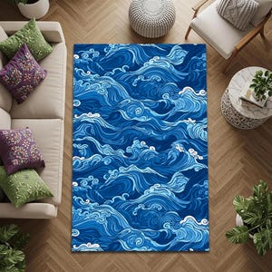 May include: A rectangular area rug featuring a repeating pattern of stylized ocean waves in various shades of blue, ranging from deep navy to light cyan, with white foam accents creating a continuous, flowing design across the entire surface.