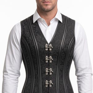 Könnte beinhalten: Eine schwarze Korsettweste mit dezentem, tonalen Blumen-Brokatmuster, vertikalen Paspeldetails und fünf silberfarbenen Metallhakenverschlüssen auf der Vorderseite. Das Kleidungsstück wird über einem weißen Langarmhemd mit Kragen getragen.