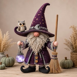 May include: A crocheted wizard gnome wearing a tall purple hat with gold star embroidery and a silver crescent moon. The gnome has a long gray beard, a pink nose, and a purple robe with wooden buttons. It holds a glowing purple lantern and a broom.