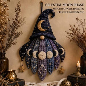 May include: A crochet wall hanging featuring a dark blue witch hat with a gold crescent moon and star accents. Below the hat, a beard displays the moon phases in cream, blue, and purple yarn with embroidered constellations and star details.