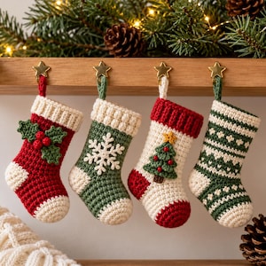 May include: Four small crocheted Christmas stockings hanging from gold star-shaped hooks. The stockings feature festive designs including holly berries, a white snowflake, a green Christmas tree, and a green and white geometric pattern.