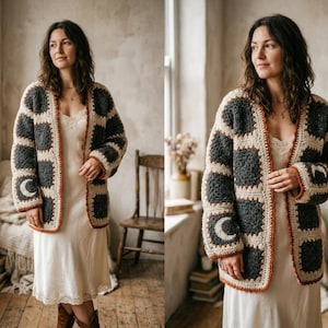 May include: A long-sleeved crochet cardigan featuring a patchwork design of dark grey and cream-coloured squares. Some dark grey squares display a crescent moon motif. The garment has a cream-coloured border and a thin rust-orange trim along the edges.