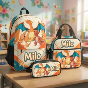 May include: A backpack, a lunch bag, and a pencil case set featuring the name Milo and illustrations of orange dragon-like creatures with blue wings. The items have a cream, orange, and blue geometric pattern with black trim and mesh side pockets.