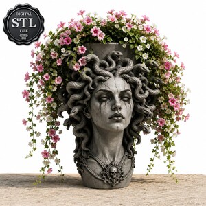 Op de afbeelding: Een grijze plantenbak met steenstructuur in de vorm van een menselijk hoofd met slangen als haar, voorzien van een schedelhanger en donkere markeringen onder de ogen. De plantenbak is gevuld met groene ranken en kleine roze en witte bloemen.