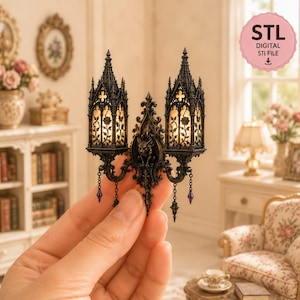Puede incluir: Un aplique de pared gótico en miniatura con dos linternas ornamentadas con patrones de rosas intrincados y agujas puntiagudas. El accesorio de metal oscuro incluye un detalle central de gárgola y pequeños acentos morados colgantes. Archivo STL.