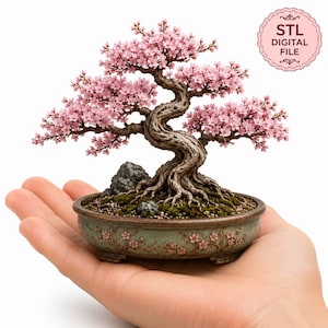 May include: A miniature bonsai tree with a twisted brown trunk and numerous small pink cherry blossoms. The tree is planted in a round, sage green ceramic pot decorated with floral reliefs. A pink circular badge reads STL DIGITAL FILE.