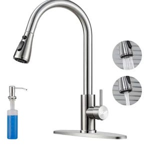 May include: A stainless steel kitchen faucet with a high-arc pull-down sprayer head, a single side-mounted lever handle, and a rectangular base plate. Included is a separate soap dispenser with a clear bottle containing blue liquid soap.